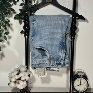 Photographie d'un jean accroché à un cintre.