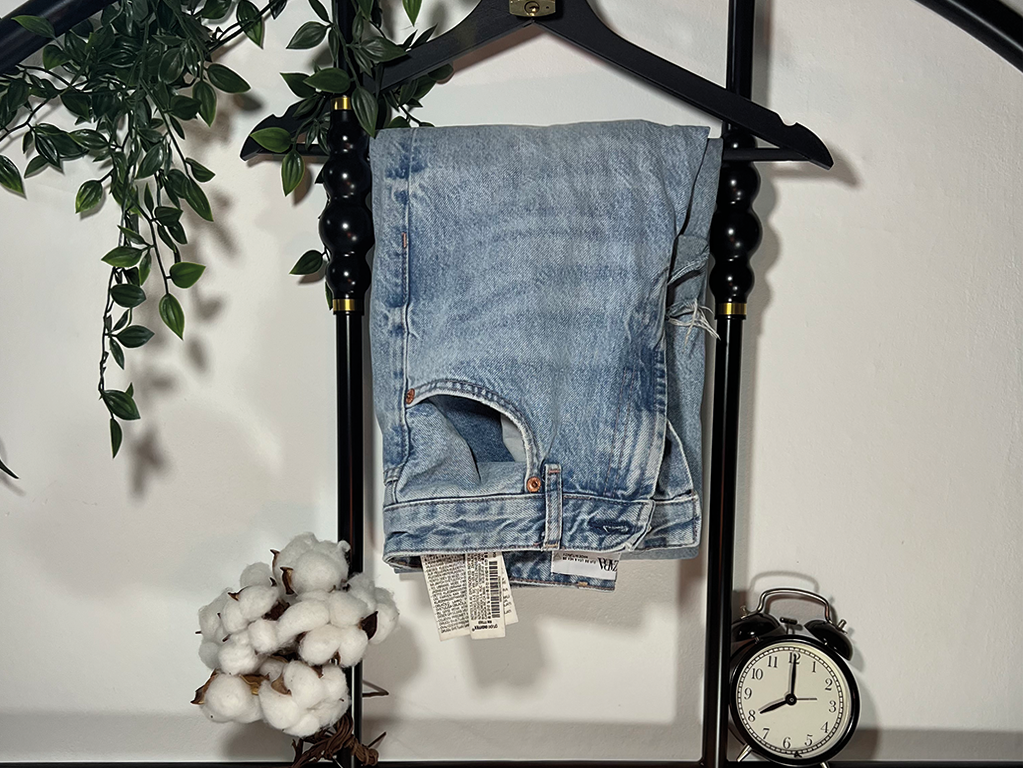 Photographie d'un jean accroché à un cintre.